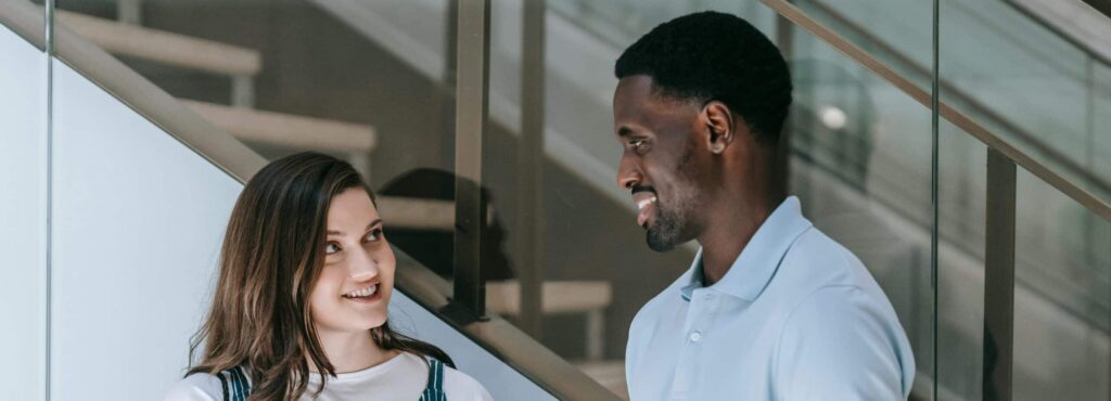 Woman in attentive conversation with a man trying to understand what he's saying in French