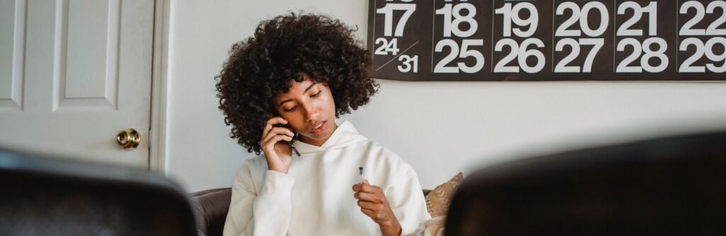 Woman on the phone writing down an appointment in her planner